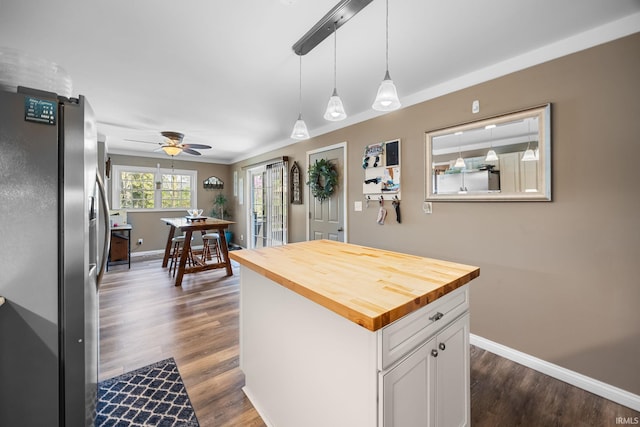 kitchen featuring baseboards, freestanding refrigerator, white cabinetry, and wooden counters