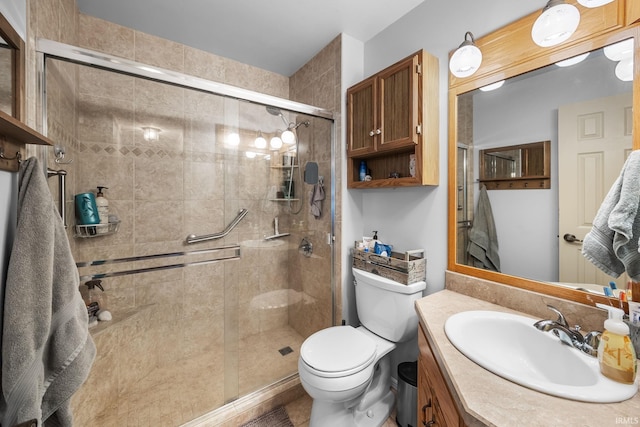 full bathroom featuring vanity, a stall shower, and toilet