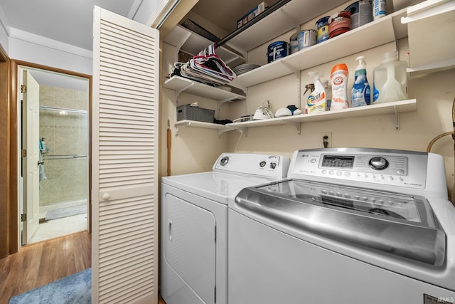 washroom featuring laundry area, wood finished floors, and washing machine and clothes dryer