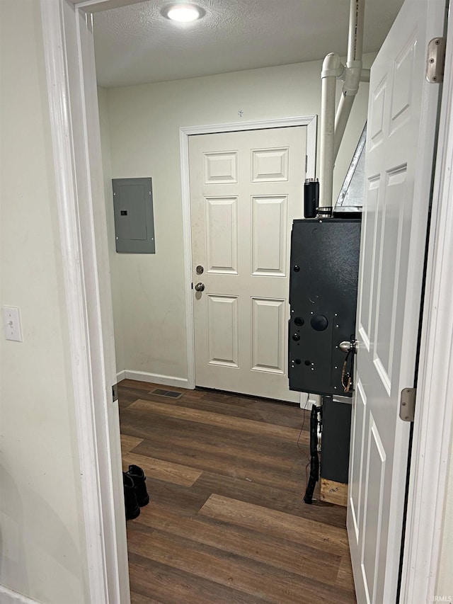 hall with baseboards, dark wood finished floors, and electric panel