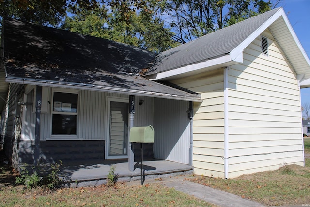 view of front of property featuring roof with shingles and covered porch