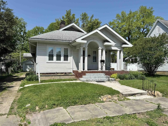 bungalow with roof with shingles, a front lawn, a garage, a porch, and a chimney