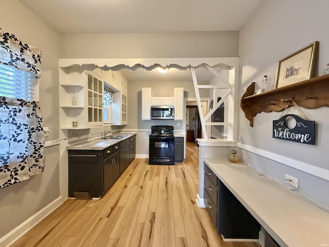 kitchen featuring light wood-style floors, open shelves, stainless steel microwave, and black range with electric stovetop