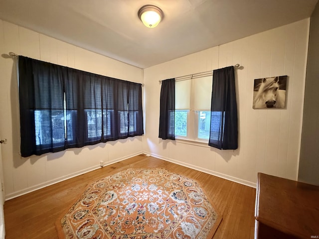 unfurnished room with baseboards and wood finished floors