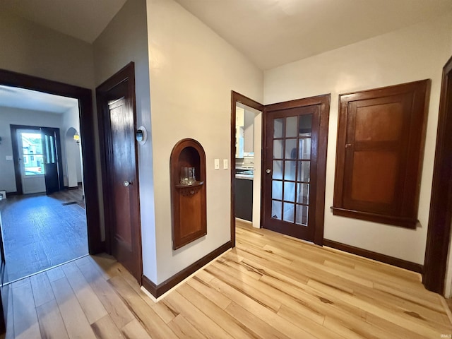 corridor featuring light wood-style floors and baseboards
