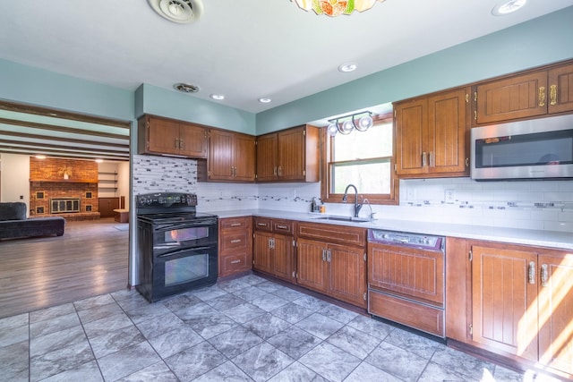 kitchen featuring a sink, light countertops, stainless steel microwave, double oven range, and paneled dishwasher
