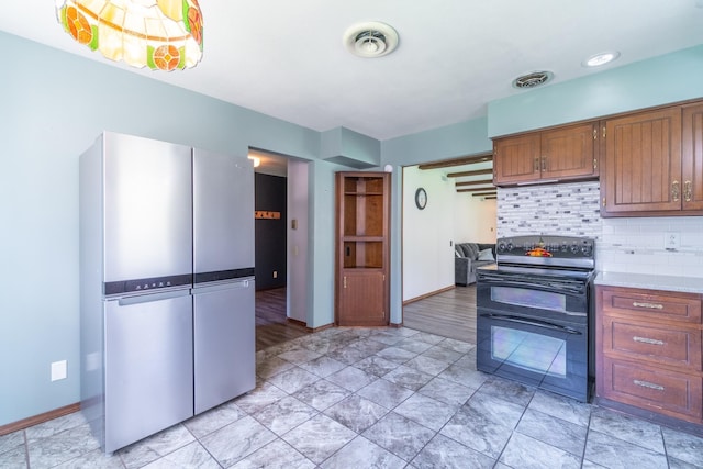kitchen featuring light countertops, baseboards, double oven range, and visible vents