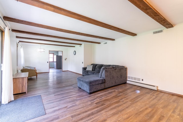 living area with visible vents, wood finished floors, baseboard heating, and beam ceiling