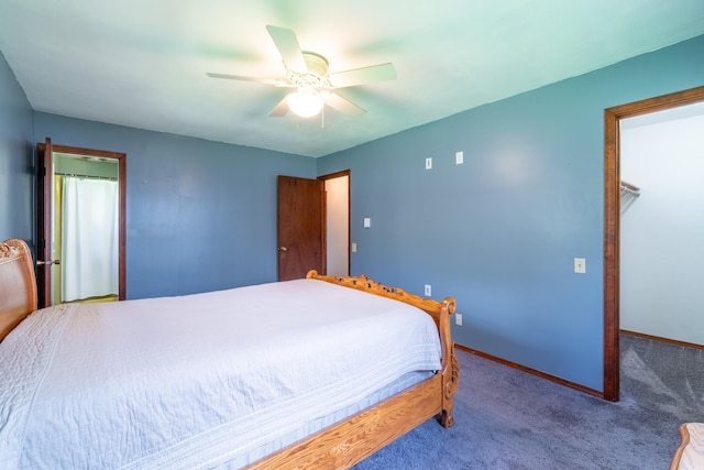 carpeted bedroom featuring baseboards, a walk in closet, a closet, and ceiling fan