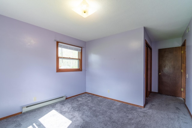 carpeted spare room featuring baseboards and a baseboard radiator