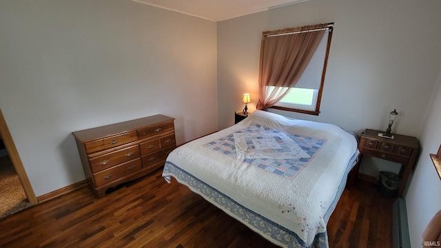 bedroom featuring baseboards, a baseboard heating unit, and dark wood-style floors