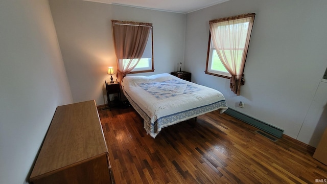 bedroom featuring baseboards, baseboard heating, and wood finished floors