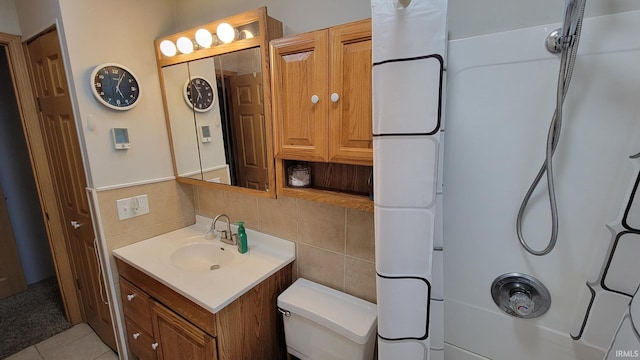 bathroom with vanity, walk in shower, toilet, and tile walls