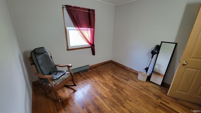 sitting room with wood-type flooring, baseboards, and ornamental molding