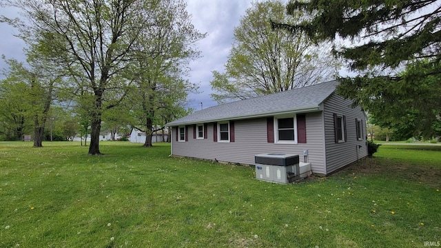 view of home's exterior featuring a shingled roof and a yard