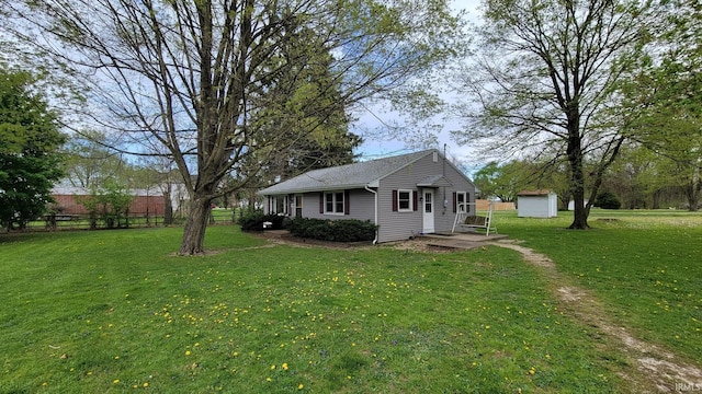 view of yard featuring an outdoor structure, fence, and a storage shed