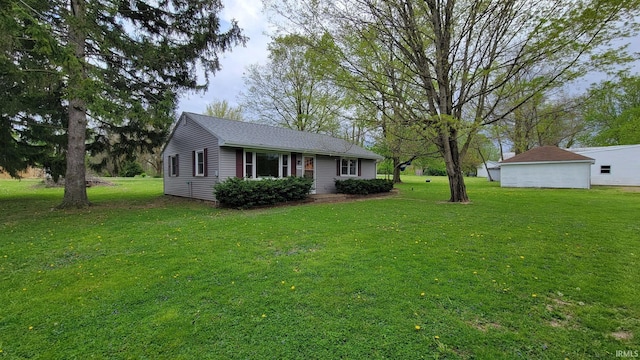 view of front of home featuring a front yard and a detached garage