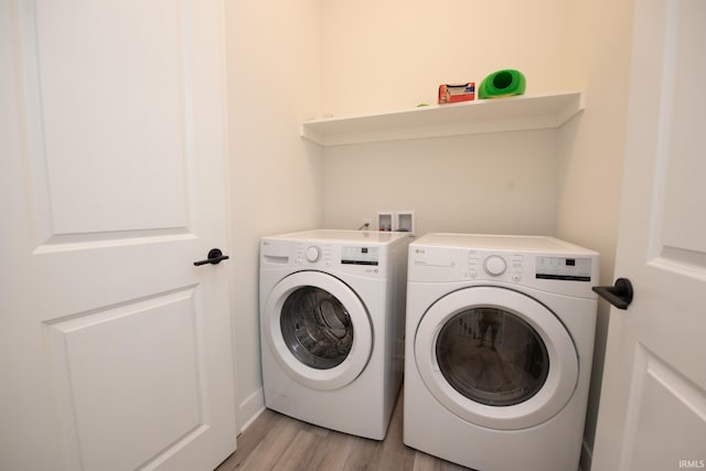 laundry area with light wood finished floors and washer and dryer