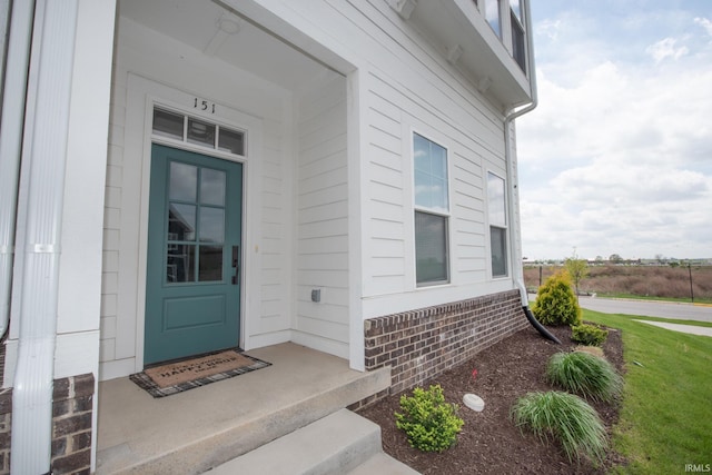 doorway to property with brick siding