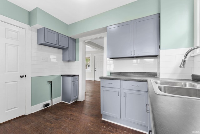 2922 Plaza Dr, Fort Wayne, IN 46806 - kitchen featuring gray cabinetry, decorative backsplash, a sink, and dark wood-type flooring