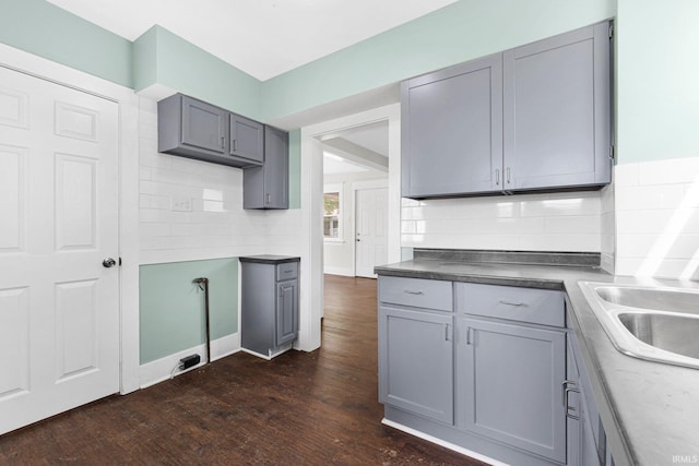 2922 Plaza Dr, Fort Wayne, IN 46806 - kitchen featuring gray cabinetry, decorative backsplash, a sink, and dark wood-type flooring