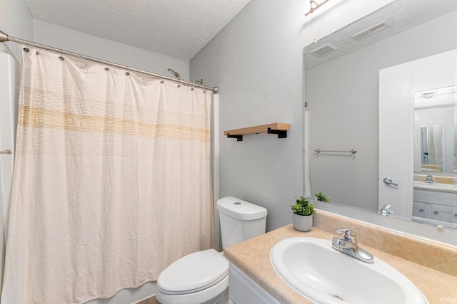 bathroom featuring visible vents, a textured ceiling, toilet, and vanity