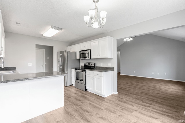 kitchen with light wood-style floors, white cabinetry, a sink, appliances with stainless steel finishes, and a notable chandelier
