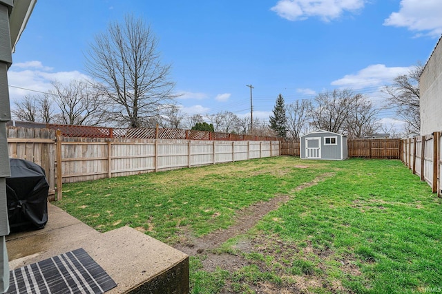 view of yard with an outdoor structure, a fenced backyard, and a shed