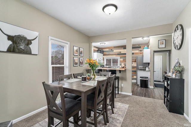 carpeted dining room with baseboards