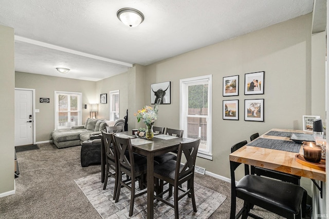 carpeted dining area with baseboards