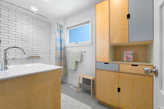 full bath with a sink, curtained shower, and tasteful backsplash