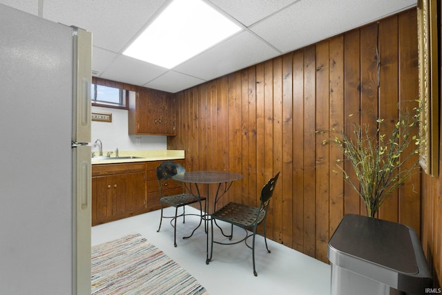 dining room featuring wood walls and a paneled ceiling