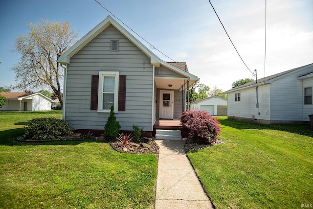view of front of home featuring a garage, an outdoor structure, and a front lawn