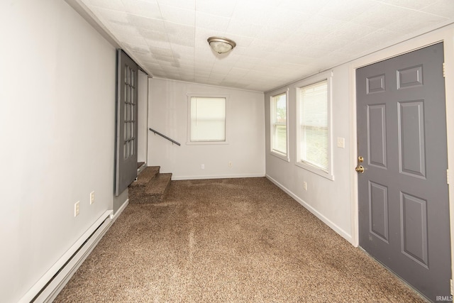 interior space with stairs, baseboards, baseboard heating, and carpet