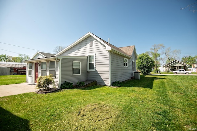 view of side of home featuring a yard and cooling unit