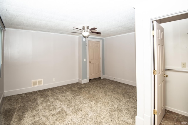 unfurnished bedroom featuring crown molding, ceiling fan, carpet, baseboards, and visible vents