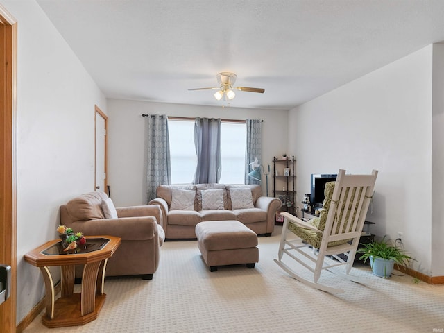 living area with carpet flooring, a ceiling fan, and baseboards