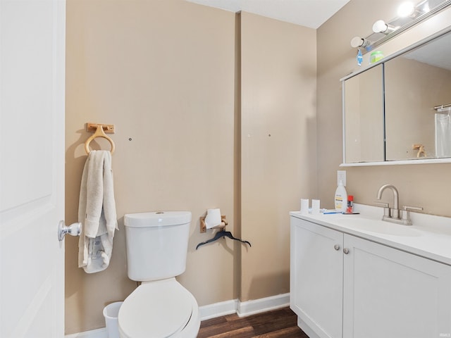 full bath with baseboards, vanity, toilet, and wood finished floors