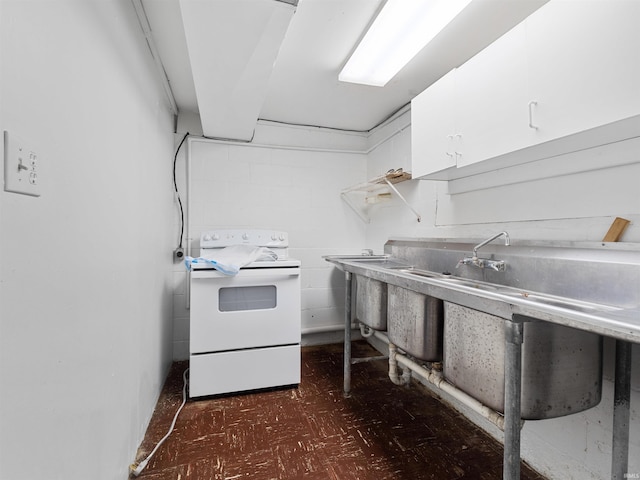 kitchen featuring light countertops, tile patterned floors, electric range, and white cabinetry