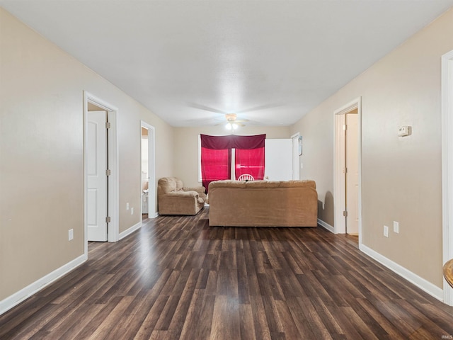 living room featuring baseboards, a ceiling fan, and dark wood finished floors