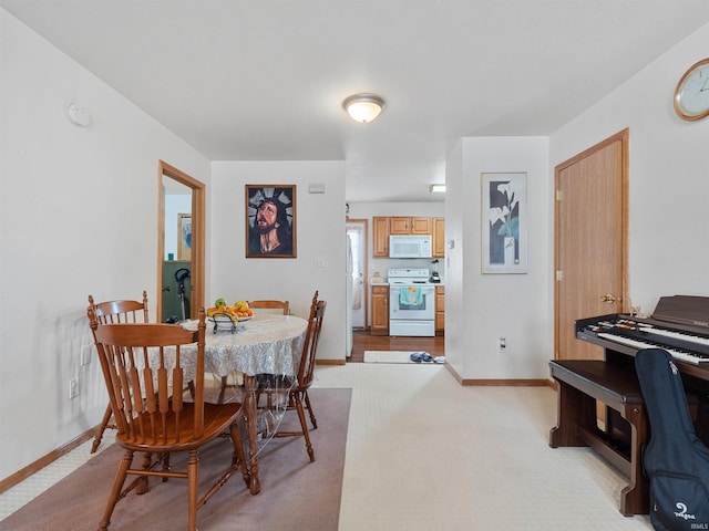 dining area featuring baseboards and light colored carpet