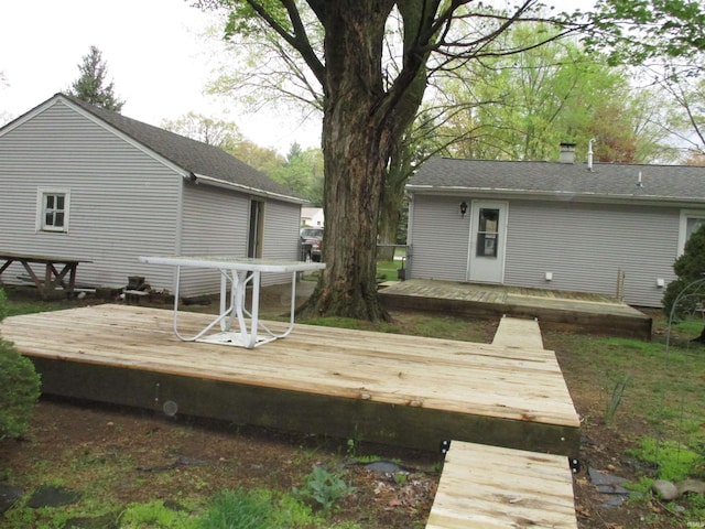 back of house with a chimney and a deck