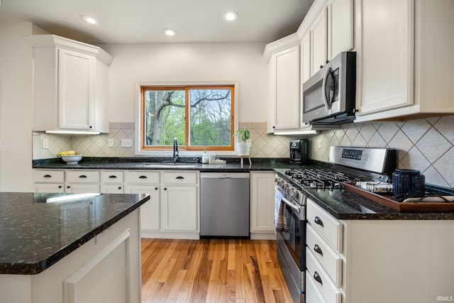 kitchen featuring a sink, appliances with stainless steel finishes, and white cabinets