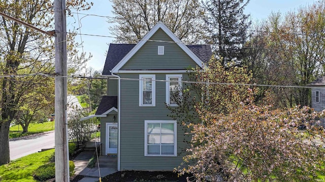 view of side of property featuring a shingled roof