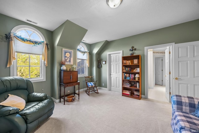 living area with carpet floors, visible vents, and a wealth of natural light