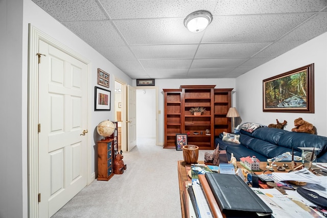 living room featuring light colored carpet and a paneled ceiling