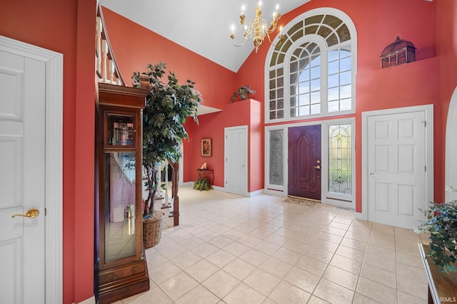foyer with tile patterned flooring, baseboards, a notable chandelier, and high vaulted ceiling