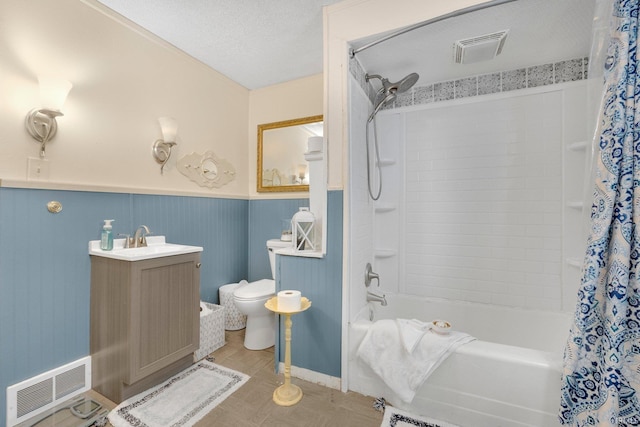 full bath with visible vents, shower / tub combo with curtain, wainscoting, and toilet