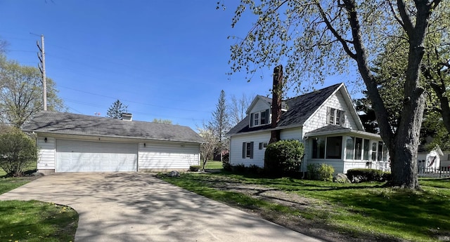 view of side of home featuring a lawn, an outbuilding, and a sunroom