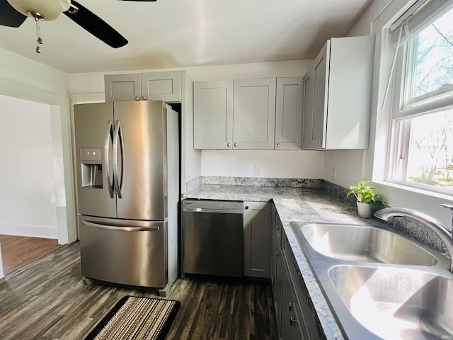 kitchen with a sink, appliances with stainless steel finishes, plenty of natural light, and dark wood-style floors